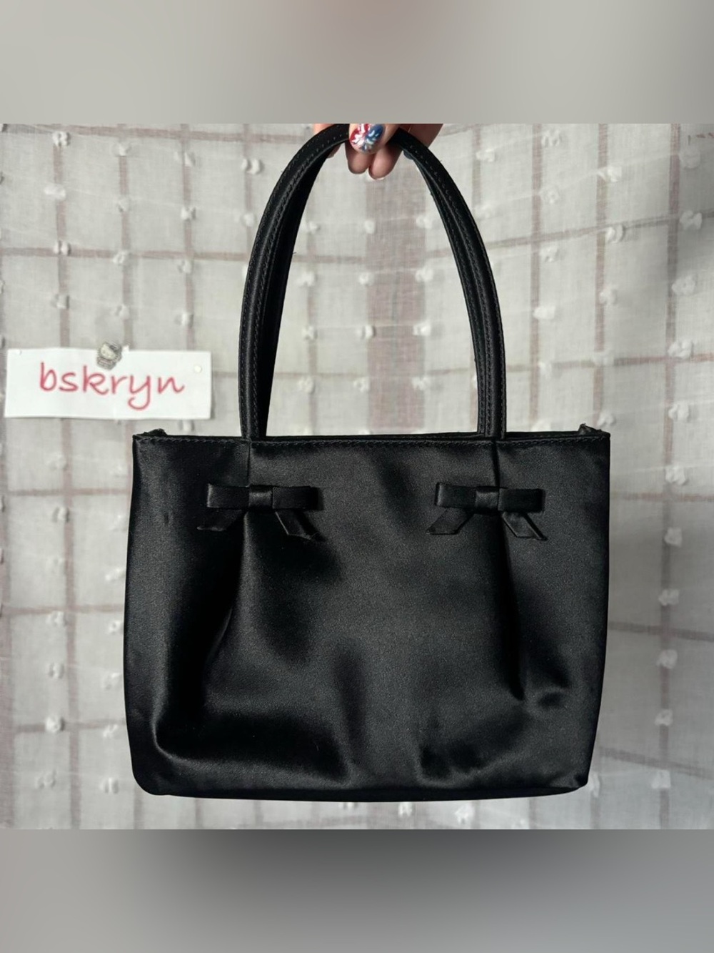 Ann Taylor LOFT top handle bag features a prominent double bow accent.